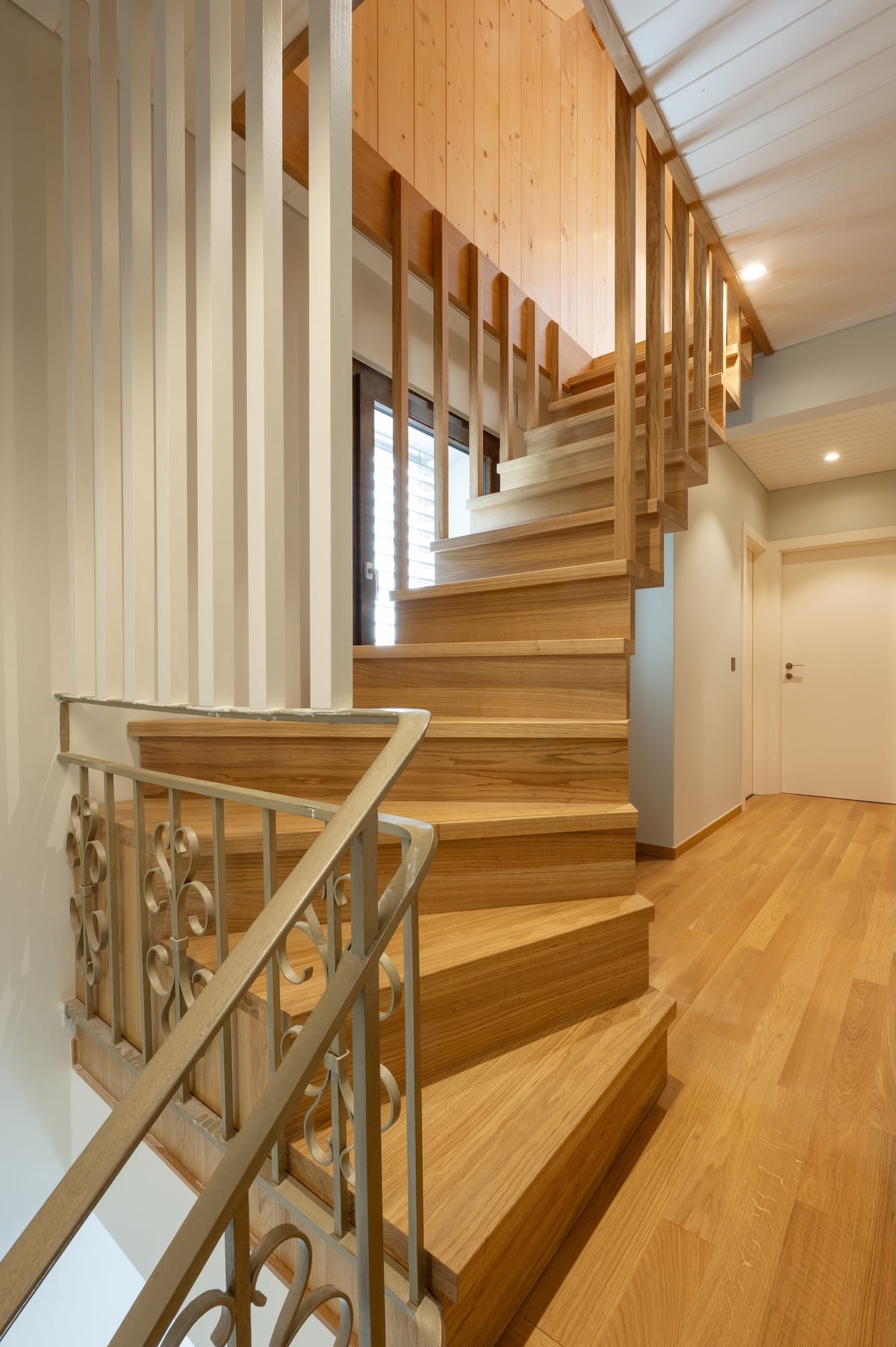 Escalier suspendu moderne en chêne massif avec garde-corps en claustra de bois.